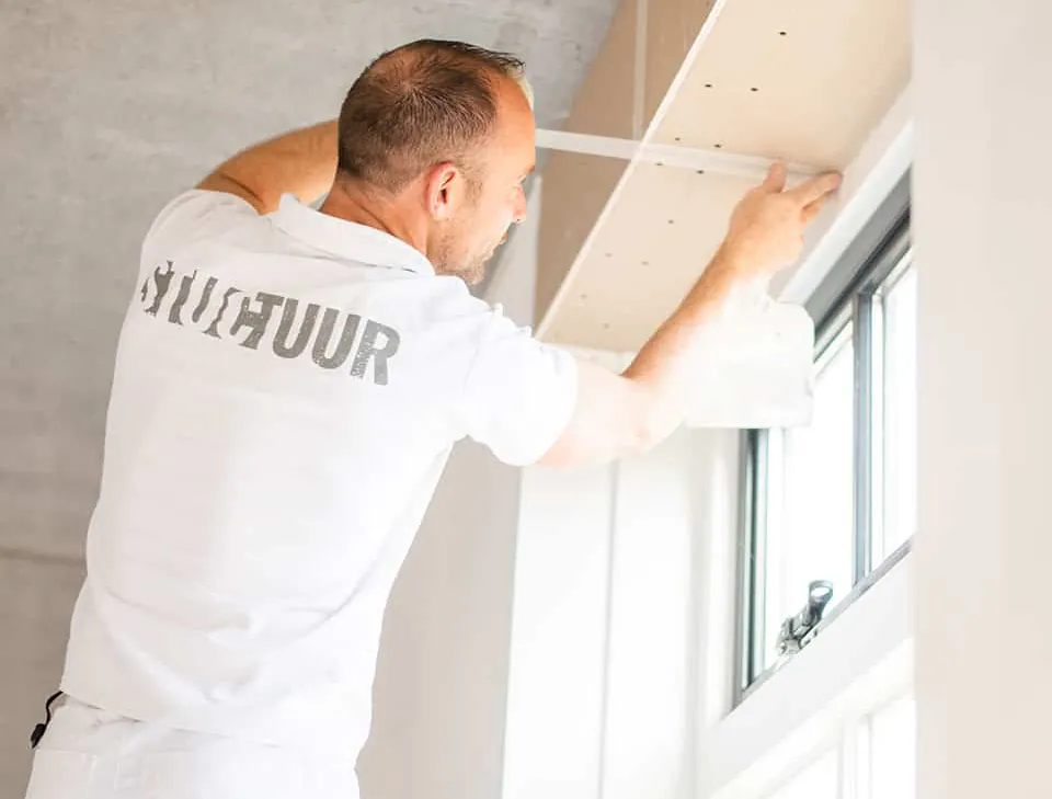 Stukadoor van Stuctuur bij een raamkozijn